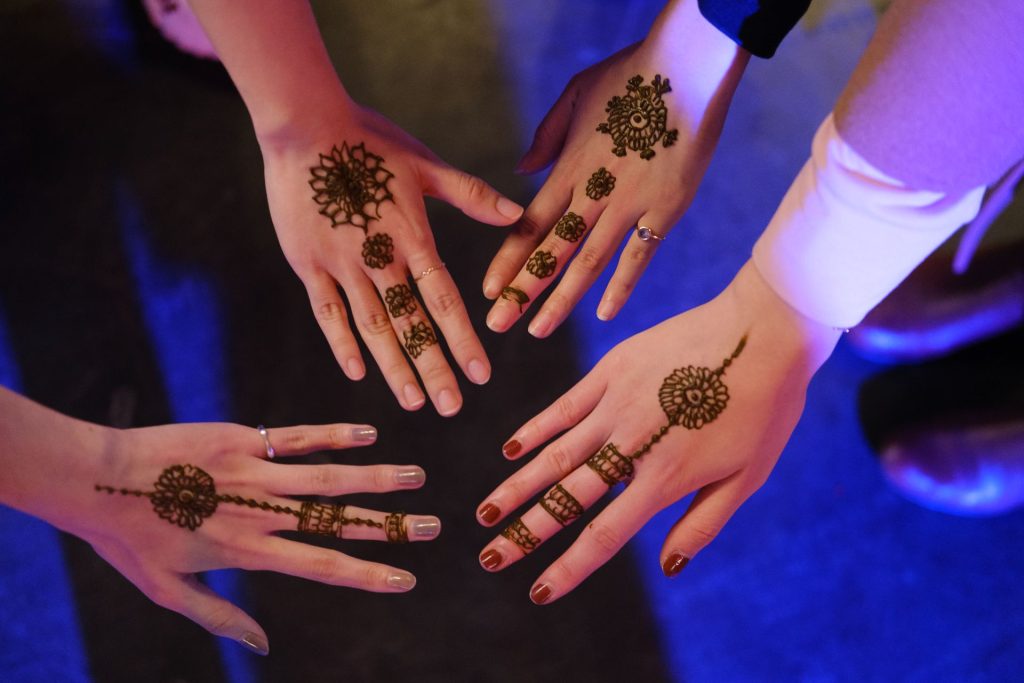 Close up of henna designs with 4 hands